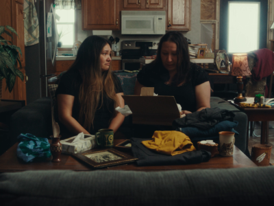 Two people sitting on a couch inside their home.